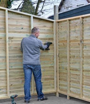 Pihavaraston päätyseinän ruuvaaminen tolppaan Pihavaraston päätyseinän ruuvaaminen tolppaan